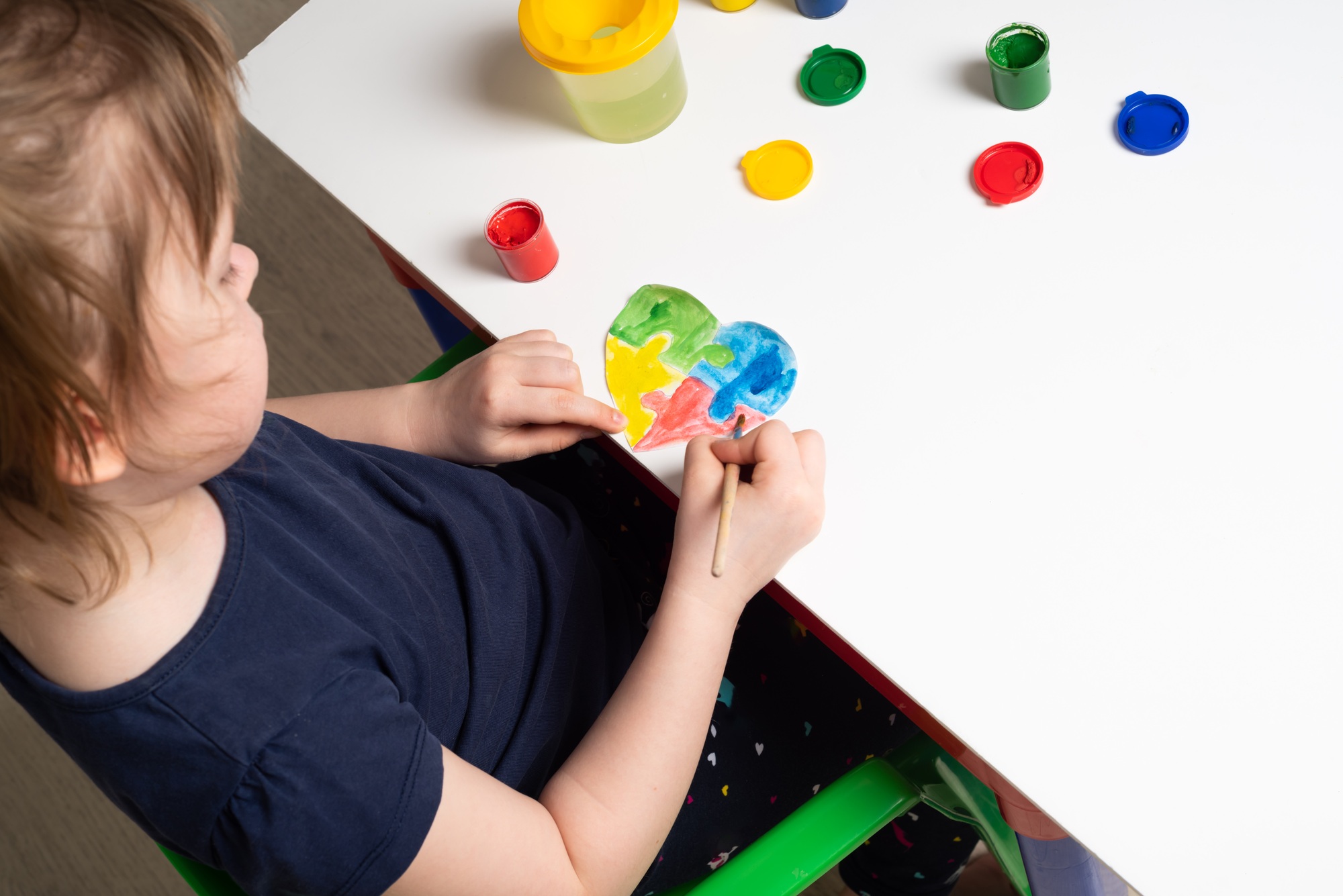 Children coloring hearts for World Autism Awareness Day