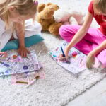 Girls Drawing in Coloring Books on Floor