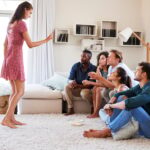 Group Of Friends At Home Having Fun Playing Charades Together