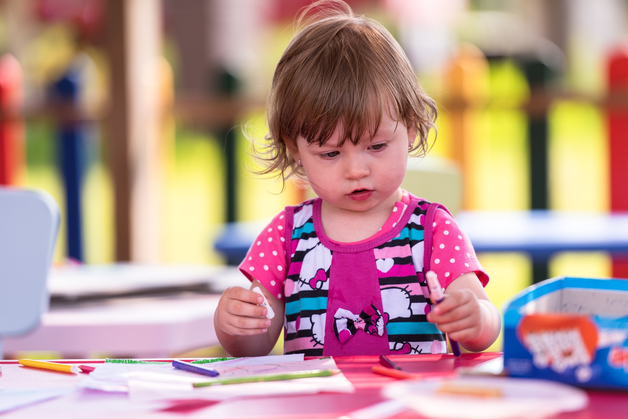 little girl drawing a colorful pictures